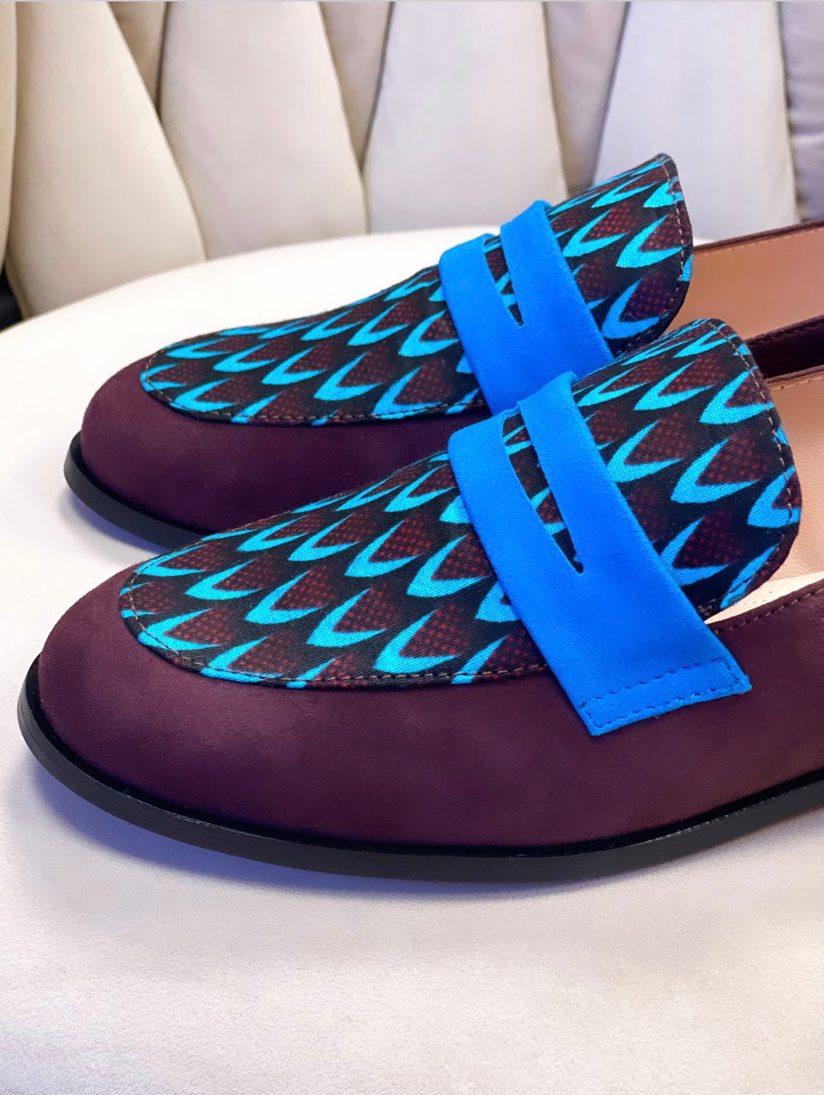 Ces mocassins faits main en cuir souple bordeaux et tissu ethnique africain bleu incarnent le mélange ultime de confort, d'élégance et d'authenticité. Chaque paire est unique, conçue pour ceux qui souhaitent allier style et culture. Que ce soit pour une journée décontractée ou une soirée spéciale, les mocassins SEULIE sont le choix idéal.