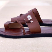 les sandales KIATEMA en cuir marron sont portées par un modèle, illustrant leur ajustement confortable et leur style élégant. La sangle tressée et la finition en cuir haut de gamme sont mises en valeur, démontrant l'artisanat sénégalais.