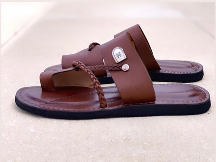 les sandales KIATEMA en cuir marron sont portées par un modèle, illustrant leur ajustement confortable et leur style élégant. La sangle tressée et la finition en cuir haut de gamme sont mises en valeur, démontrant l'artisanat sénégalais.