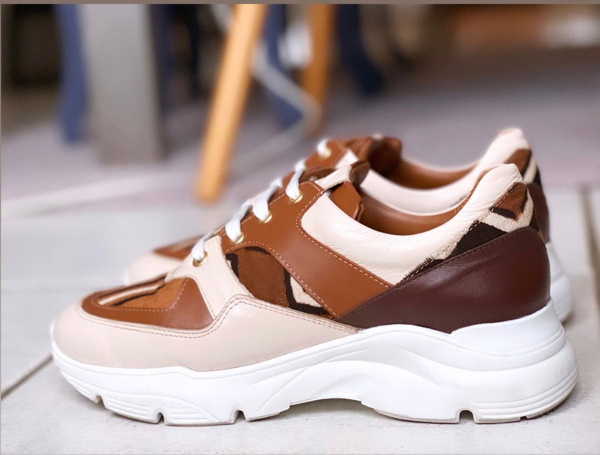 Caractéristiques: * Tige: En cuir véritable et tissu bogolan * Semelle intérieure: Confort orthopédique * Semelle extérieure: Caoutchouc robuste pour une adhérence optimale * Fermeture: Lacets en coton renforcé * Couleur: Mélange de blanc, beige et marron * Taille disponible: Du 36 au 45 Avantages: * Confort: Conception ergonomique pour un usage quotidien * Durabilité: Matériaux de haute qualité pour une longue durée de vie * Style: Design contemporain avec une touche culturelle unique * Polyvalence: Idéale