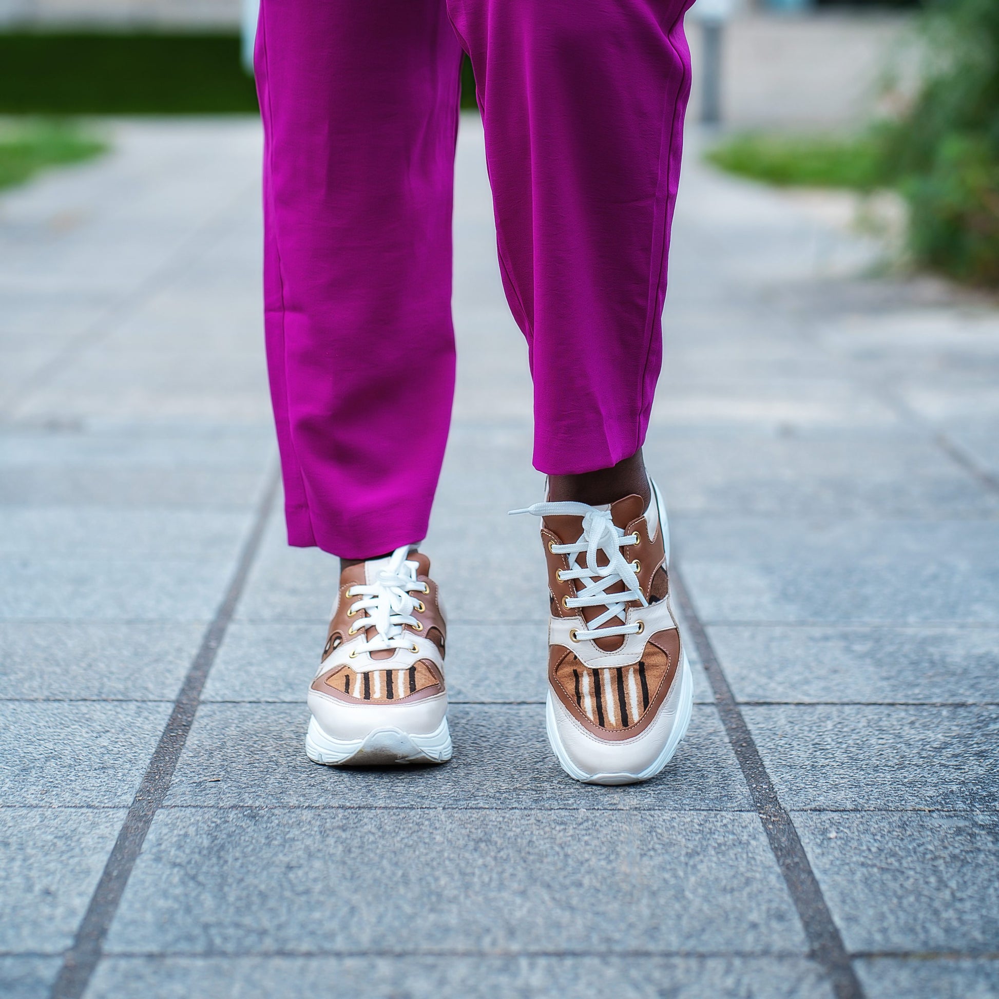 Caractéristiques: * Tige: En cuir véritable et tissu bogolan * Semelle intérieure: Confort orthopédique * Semelle extérieure: Caoutchouc robuste pour une adhérence optimale * Fermeture: Lacets en coton renforcé * Couleur: Mélange de blanc, beige et marron * Taille disponible: Du 36 au 45 Avantages: * Confort: Conception ergonomique pour un usage quotidien * Durabilité: Matériaux de haute qualité pour une longue durée de vie * Style: Design contemporain avec une touche culturelle unique * Polyvalence: Idéale