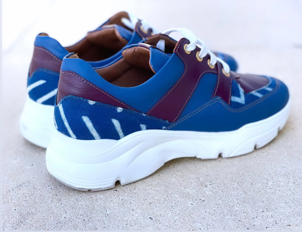 Caractéristiques: * Tige: En cuir véritable et tissu bogolan * Semelle intérieure: Confort orthopédique * Semelle extérieure: Caoutchouc robuste pour une adhérence optimale * Fermeture: Lacets en coton renforcé * Couleur: Mélange de bleu et bordeaux * Taille disponible: Du 36 au 45 Avantages: * Confort: Conception ergonomique pour un usage quotidien * Durabilité: Matériaux de haute qualité pour une longue durée de vie * Style: Design contemporain avec une touche culturelle unique * Polyvalence: Idéales pour