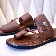 les sandales KIATEMA en cuir marron sont portées par un modèle, illustrant leur ajustement confortable et leur style élégant. La sangle tressée et la finition en cuir haut de gamme sont mises en valeur, démontrant l'artisanat sénégalais.