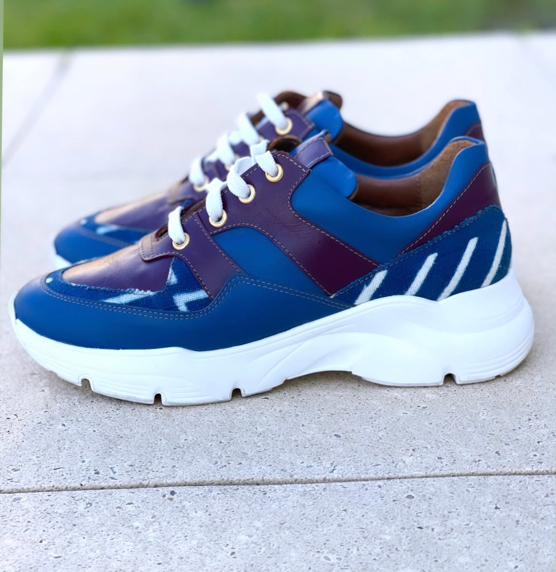 Caractéristiques: * Tige: En cuir véritable et tissu bogolan * Semelle intérieure: Confort orthopédique * Semelle extérieure: Caoutchouc robuste pour une adhérence optimale * Fermeture: Lacets en coton renforcé * Couleur: Mélange de bleu et bordeaux * Taille disponible: Du 36 au 45 Avantages: * Confort: Conception ergonomique pour un usage quotidien * Durabilité: Matériaux de haute qualité pour une longue durée de vie * Style: Design contemporain avec une touche culturelle unique * Polyvalence: Idéales pour