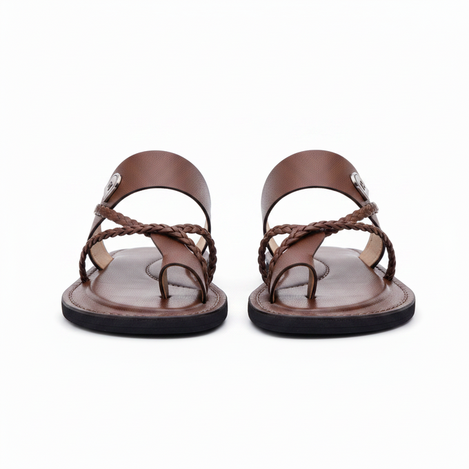 les sandales KIATEMA en cuir marron sont portées par un modèle, illustrant leur ajustement confortable et leur style élégant. La sangle tressée et la finition en cuir haut de gamme sont mises en valeur, démontrant l'artisanat sénégalais.
