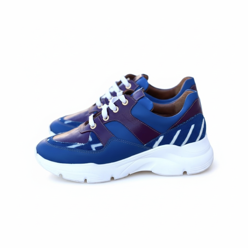 Caractéristiques: * Tige: En cuir véritable et tissu bogolan * Semelle intérieure: Confort orthopédique * Semelle extérieure: Caoutchouc robuste pour une adhérence optimale * Fermeture: Lacets en coton renforcé * Couleur: Mélange de bleu et bordeaux * Taille disponible: Du 36 au 45 Avantages: * Confort: Conception ergonomique pour un usage quotidien * Durabilité: Matériaux de haute qualité pour une longue durée de vie * Style: Design contemporain avec une touche culturelle unique * Polyvalence: Idéales pour