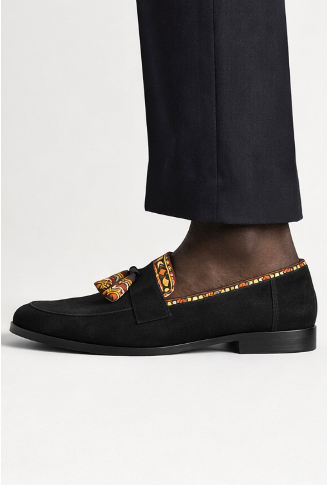 Vue de face des mocassins Himba Lubango en daim noir, bande Samakaka et pompon, fait main Portugal